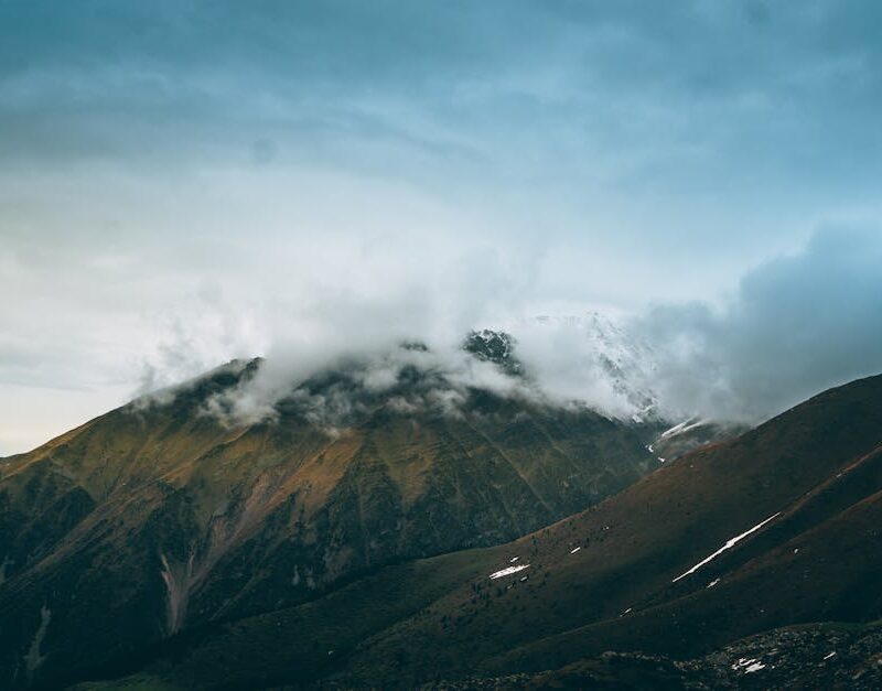 Mountain Landscapes - A stunning view of mountain peaks partially cove #12211339