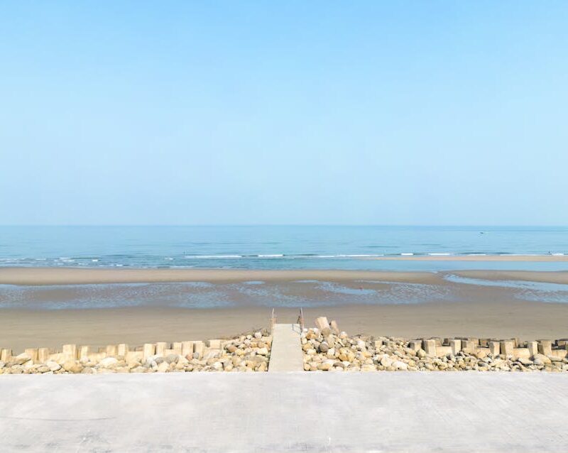 Beach Scenery - Serene coastal view with clear blue sky and a co #15902767