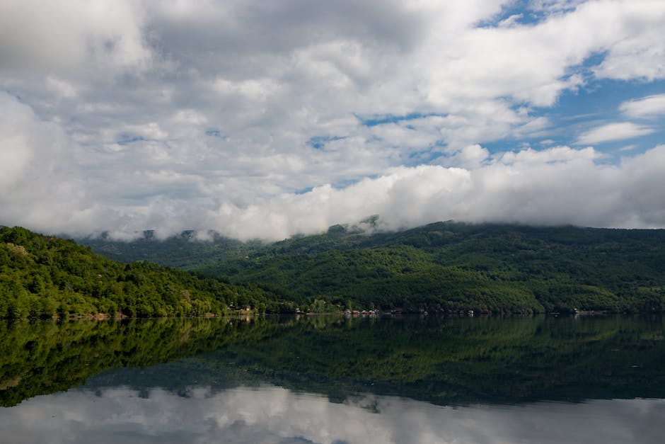 Lake Reflections - Peaceful lake with lush green hills and clouds r #25391558