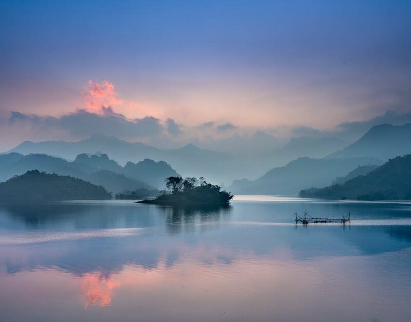 Lake Reflections - Tranquil lake with misty mountains at sunrise in #2649403