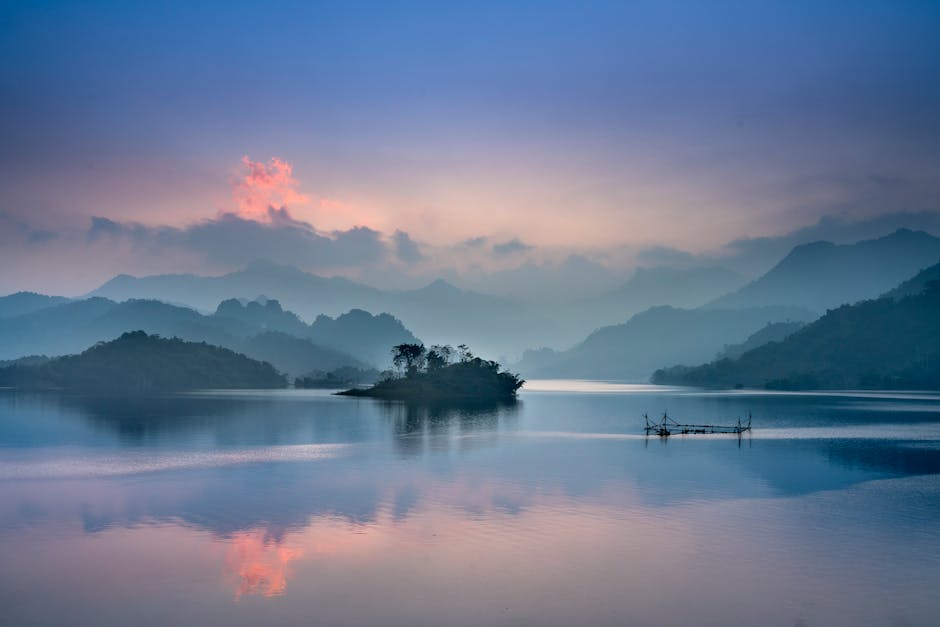 Lake Reflections - Tranquil lake with misty mountains at sunrise in #2649403