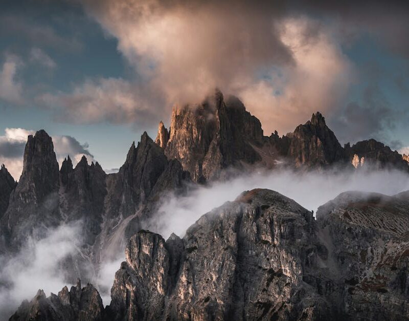 Mountain Landscapes - Majestic mountain peaks shrouded in mist at suns #28127040