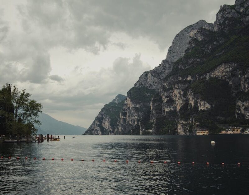 Lake Reflections - Serene view of Lake Garda with imposing cliffs a #32049157