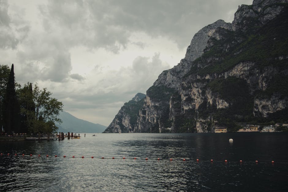 Lake Reflections - Serene view of Lake Garda with imposing cliffs a #32049157