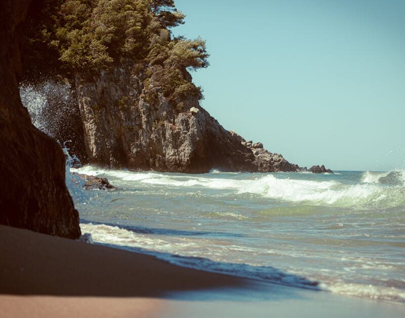Beach Scenery - Waves crash on a tranquil rocky beach under a cl #33596216