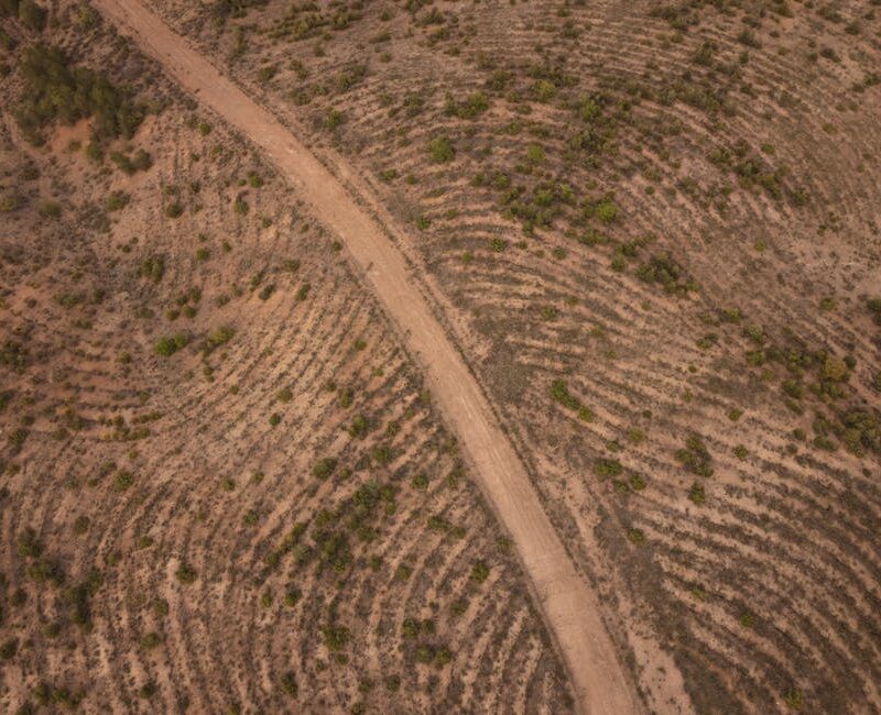 Desert Wilderness - An aerial shot of a winding dirt road through a  #34741902