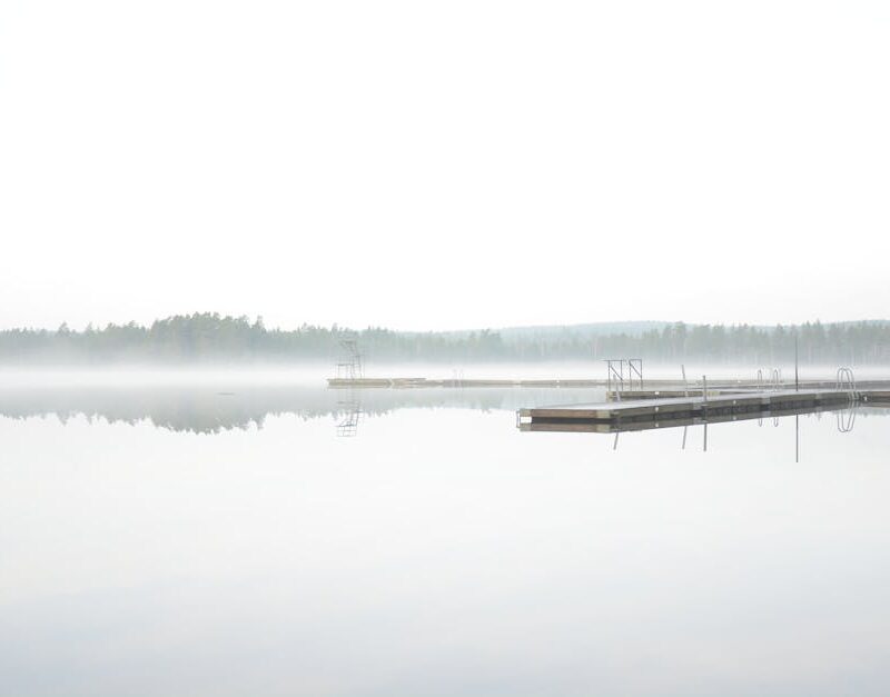 Lake Reflections - A tranquil misty lake scene with a wooden dock e #35081742