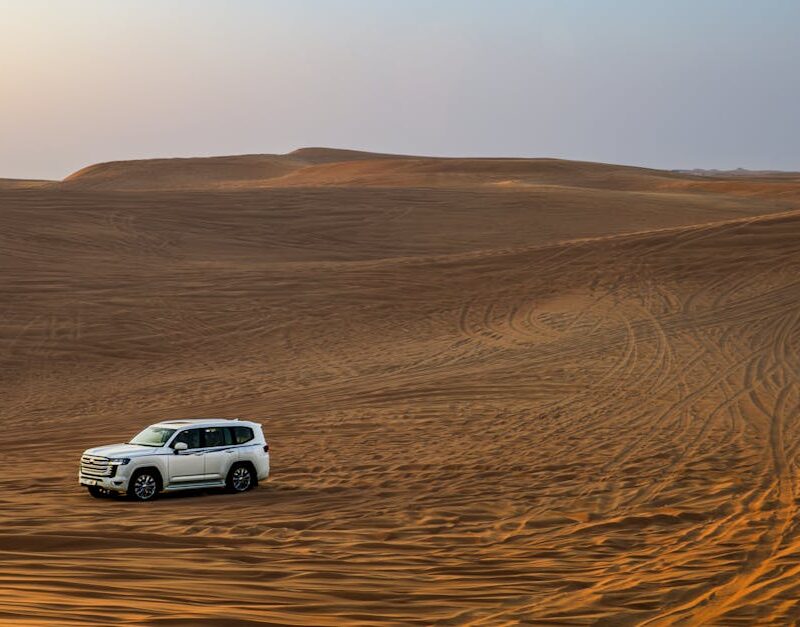 Desert Wilderness - White SUV traversing expansive desert dunes at s #35110924
