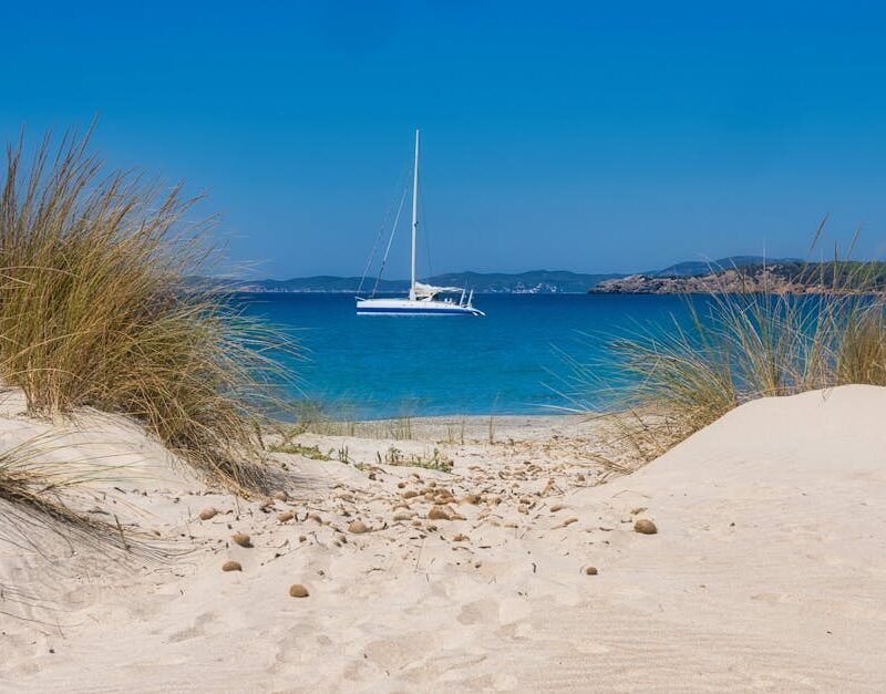 Beach Scenery - Idyllic beach view with a sailboat on clear blue #35141854